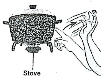 A hand jerking away after touching a hot pot on a stove.